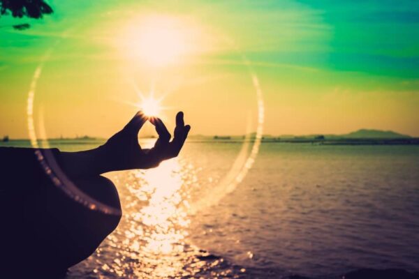 A Person’s Hand Holding Light Near A River